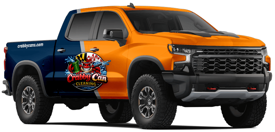 A large pickup truck with an orange and blue color scheme featuring a logo for Crabby Can Cleaning on the side.